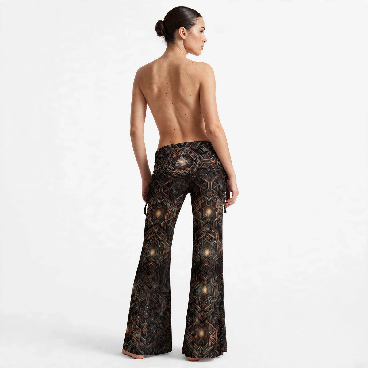 (Back) Back view of high waist wide leg pants with an all-over symmetrical geometric print and side drawstrings at the hips.