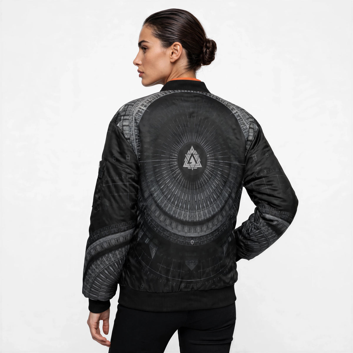Back view of the black bomber jacket showing a layered triangular emblem inside a radiating circular halo, with printed sleeves.