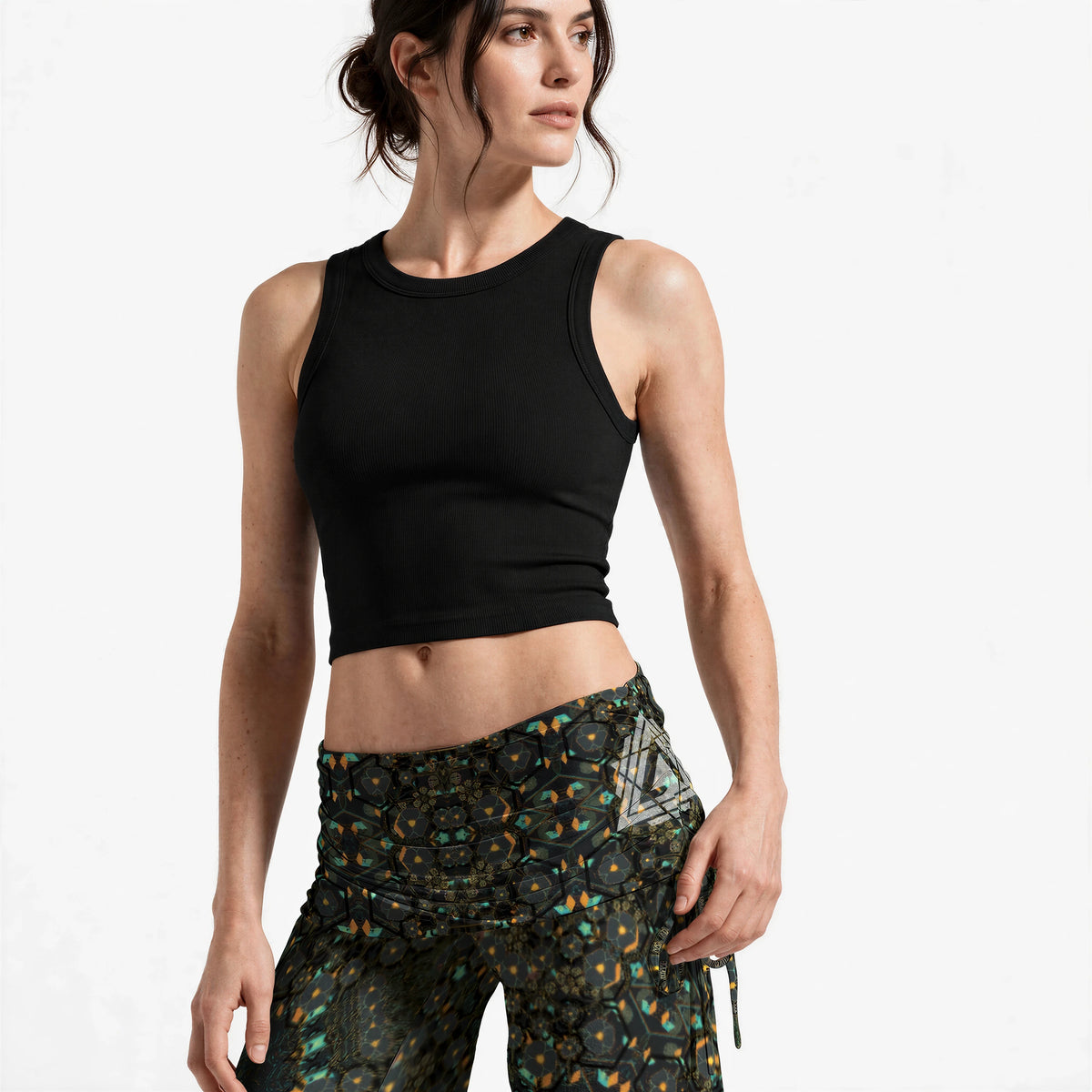 Close-up of the ruched waistband and hip, showing the mandala print detail and the silver geometric emblem at the left hip.